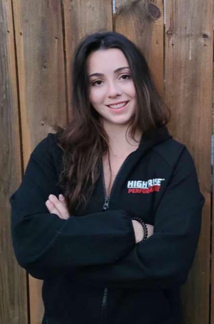 person leaning next to a wood fence